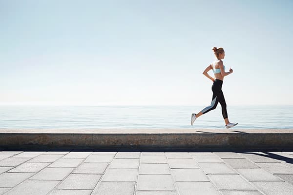 A young women running along a sea wall