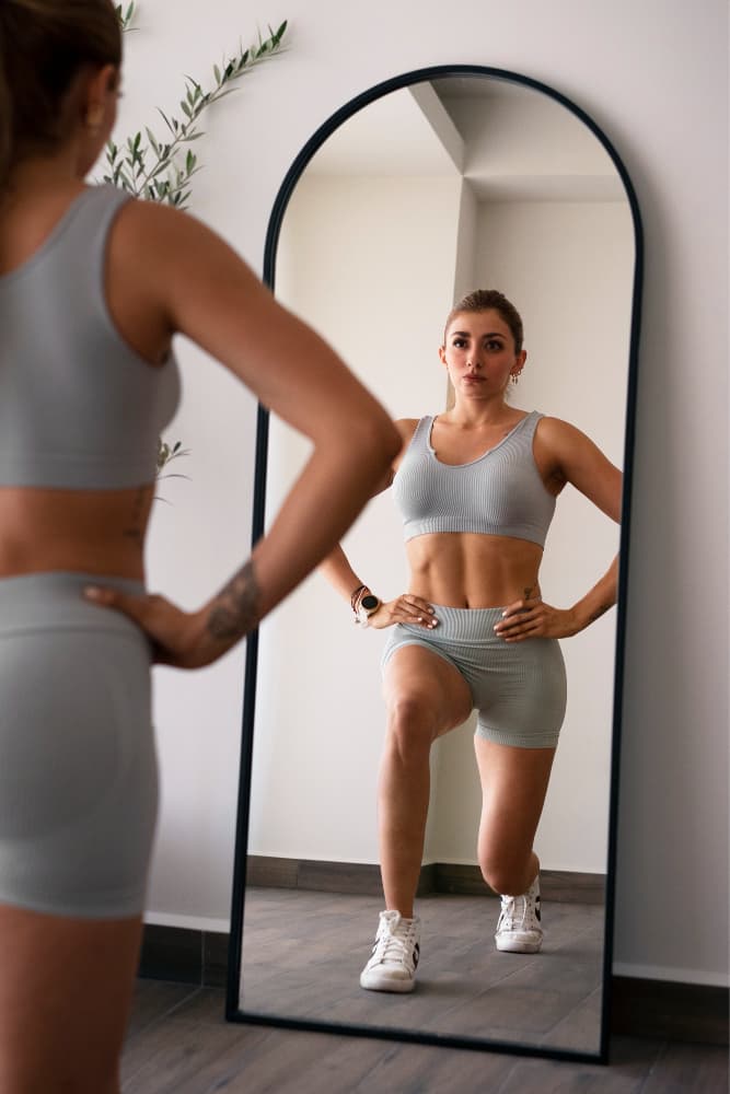 Person looking in the mirror, tracking visible progress in their body composition journey