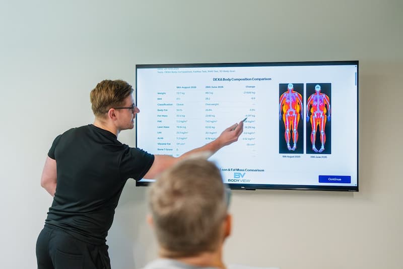 A BodyScan practitioner talking a client through their DEXA results on screen