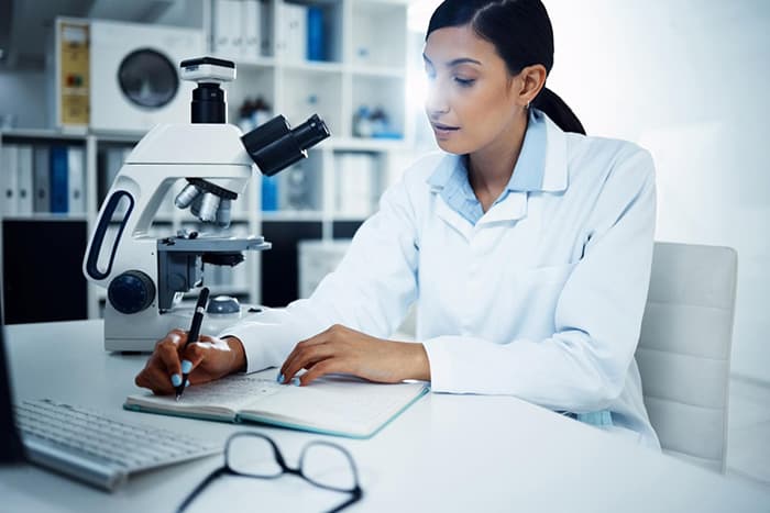 Clinician reviewing DEXA scan notes in a laboratory